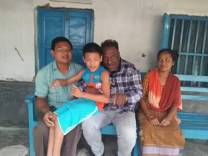 A child on a blue bench with the Chairman and his family