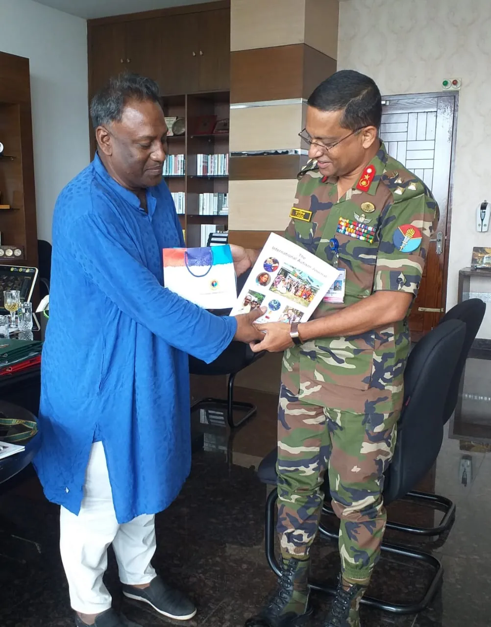 Handing a Foundation publication to a senior officer in his office