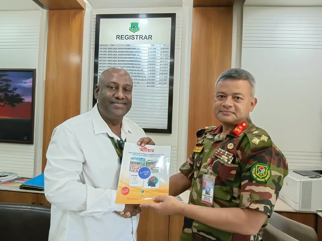 Presenting a copy of the book Autism in the Registrar's office