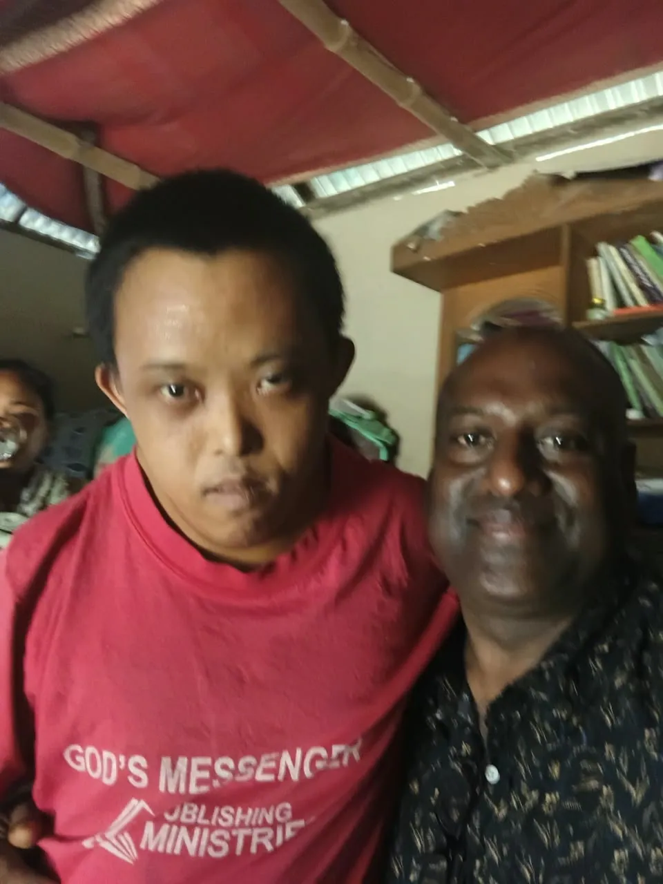 The Chairman with a young man in a red shirt
