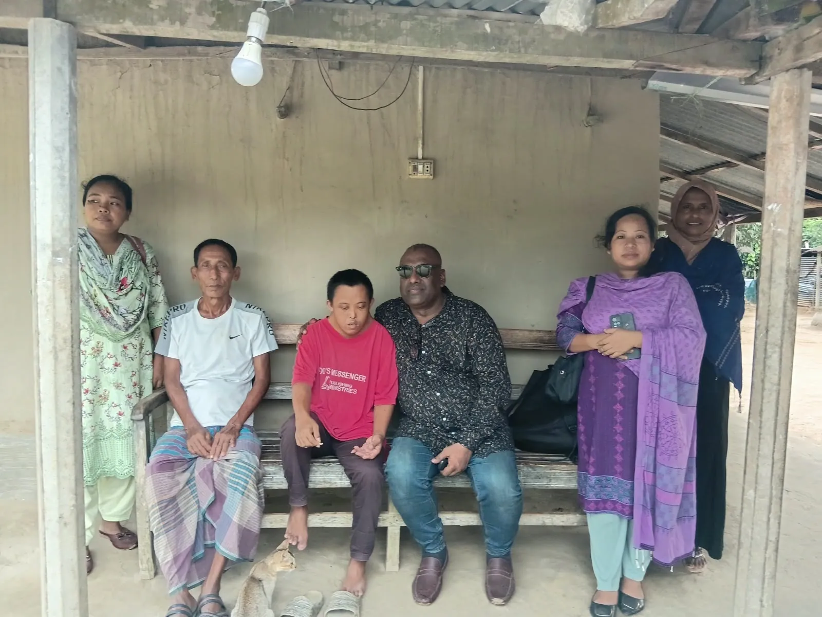 Sitting with a family on a veranda bench during a home visit