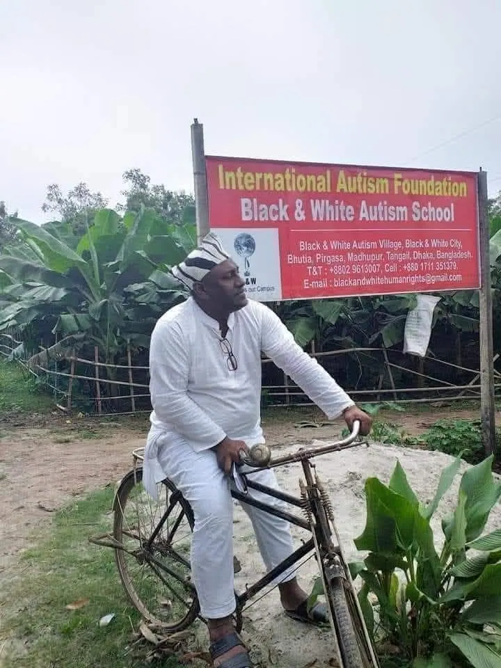 The International Autism Foundation signboard at the Madhupur campus, with the Chairman on a bicycle