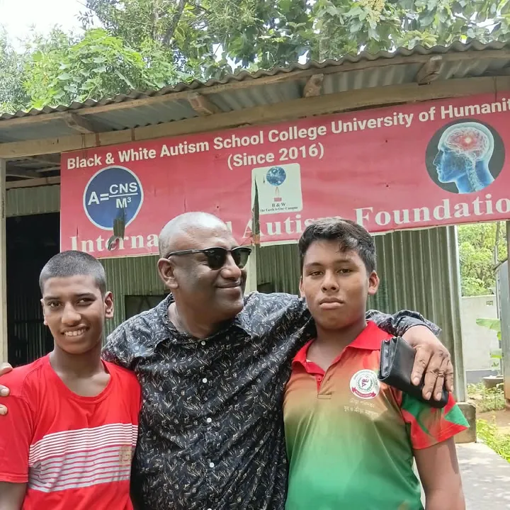 The Chairman with two boys at the school banner