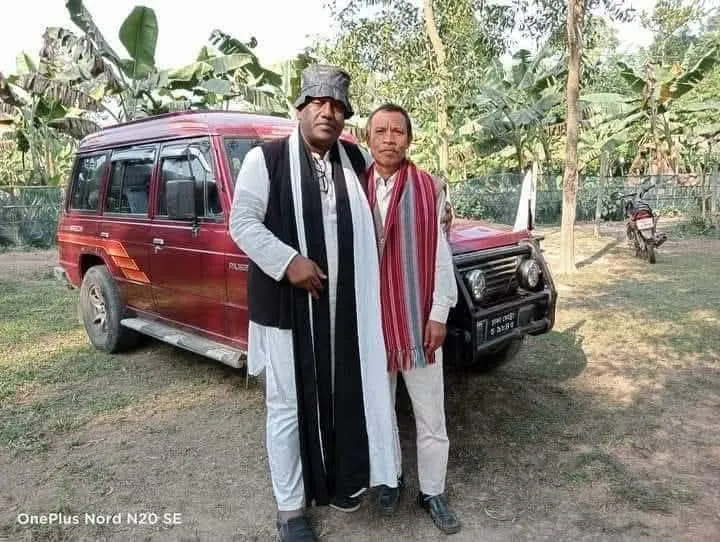The Chairman with a local man beside a red jeep in a banana grove