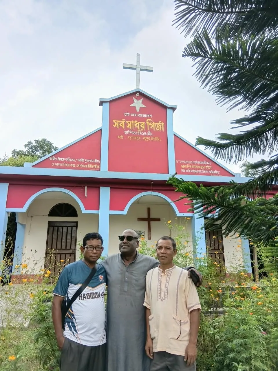 The Chairman with two men in front of a village church
