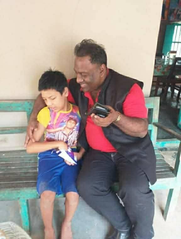 Chairman with a divine child at the Dhanbari community home